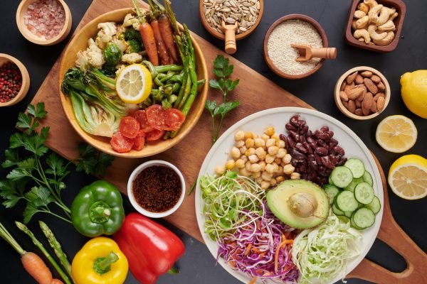 Vegan protein source. Buddha bowl dish, avocado, pepper, tomato, Vegan protein source. Buddha bowl dish, avocado, pepper, tomato, cucumber, red cabbage, chickpea, fresh lettuce salad and walnuts, nuts, beans, . Healthy vegetarian eating, super food. Top view.